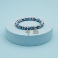 Bracciale perle vetro blu con ciondoli chiave e lucchetto su piedistallo azzurro pastello