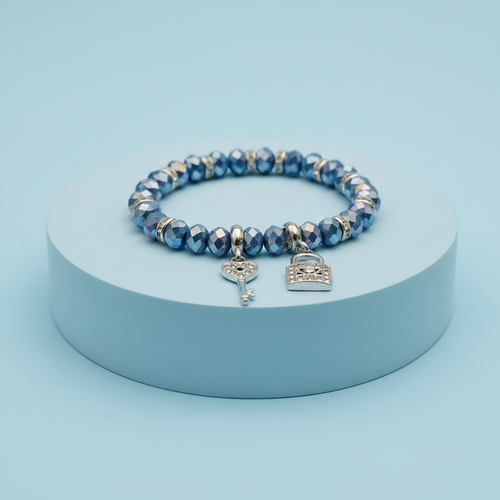 Bracciale perle vetro blu con ciondoli chiave e lucchetto su piedistallo azzurro pastello