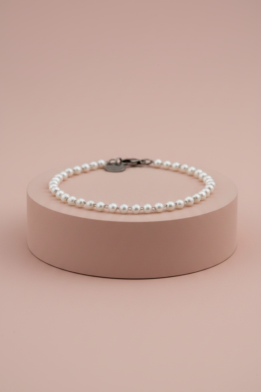 Lamù bracciale acciaio con perline bianche su piedistallo rosa cipria
