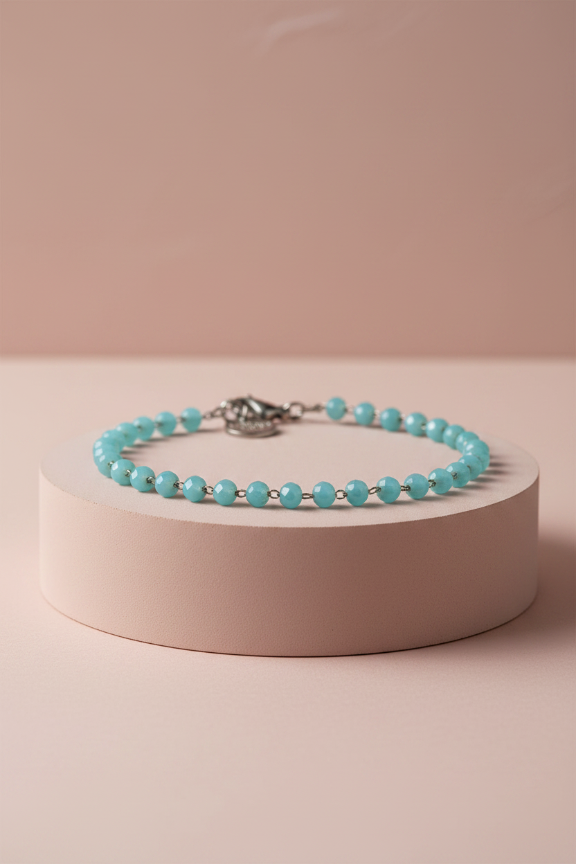 Lamù bracciale acciaio sfere vetro turchese su piedistallo rosa cipria