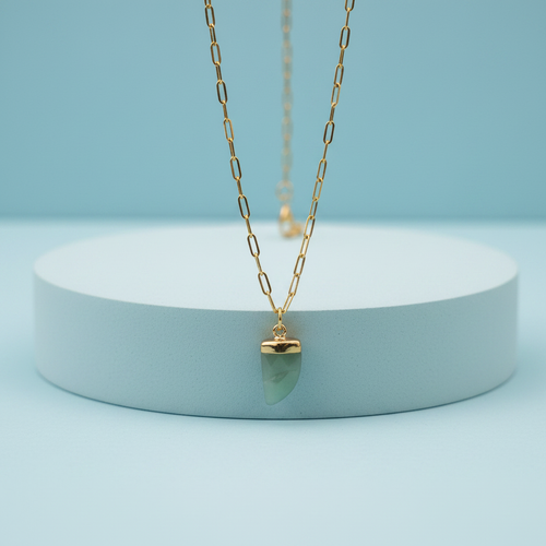 Collana corno giada verde su piedistallo azzurro pastello