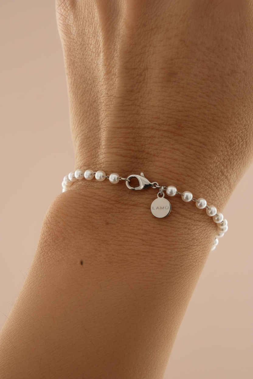 Lamù bracciale acciaio con perline bianche indossato al polso