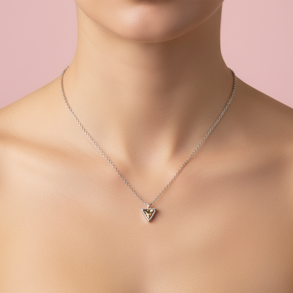 Collana triangolo zircone topazio indossata sfondo rosa cipria