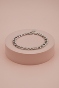 Lamù bracciale uomo acciaio catena figaro su piedistallo rosa cipria
